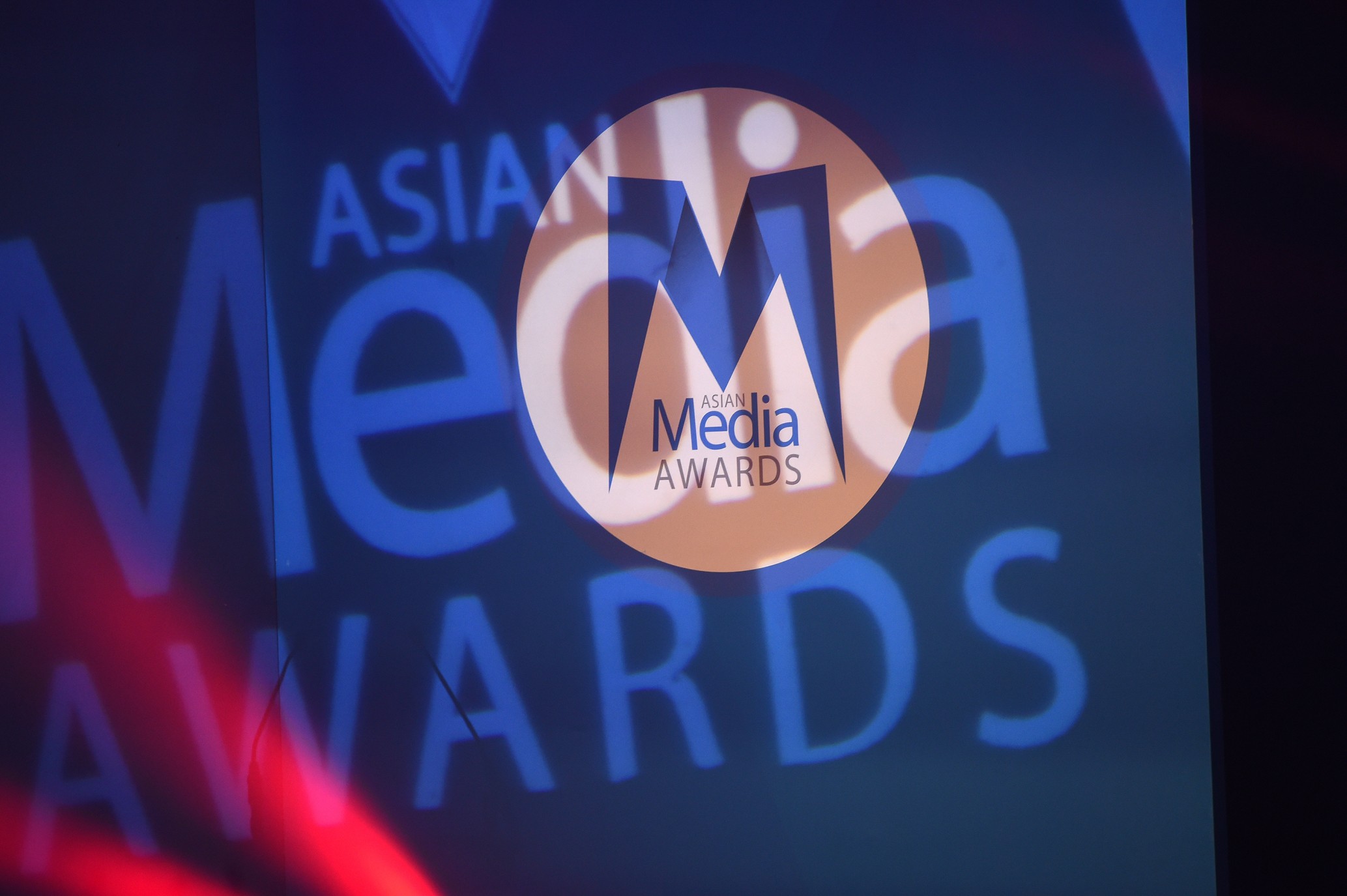 Asian Media Awards logo on a spotlight