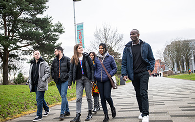 Six students walking together through Peel Park campus