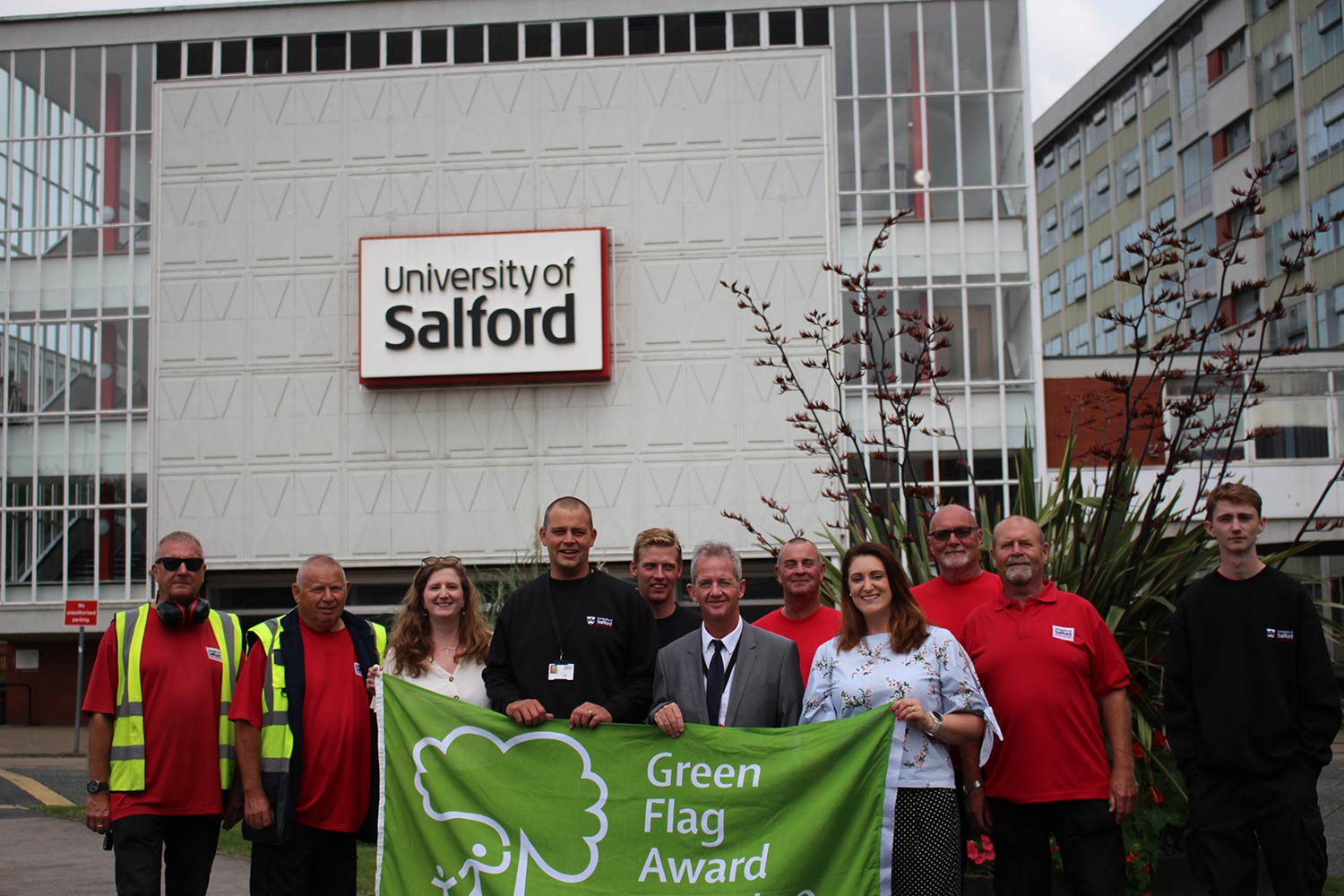 Estates and facilities staff stood with green flag