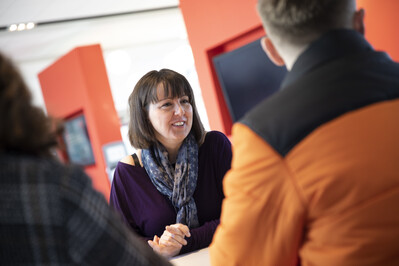 Staff member talking to two students