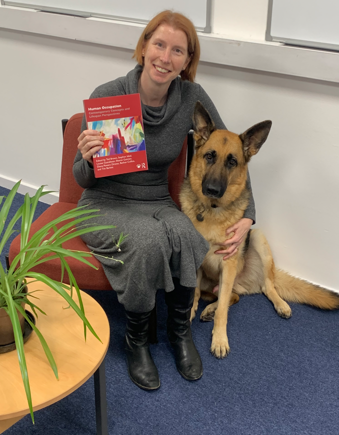 Bethan pictured with a copy of the new textbook and Huntly, her guide dog