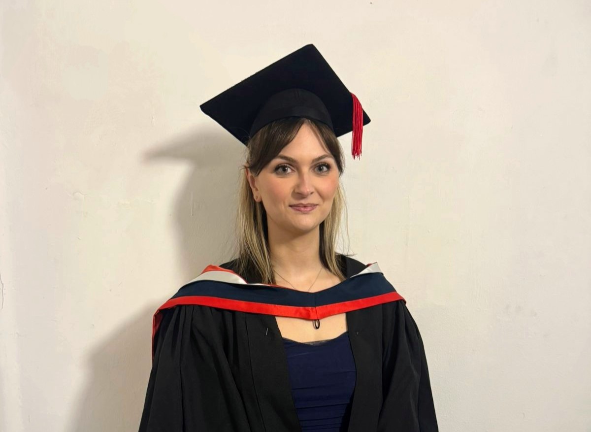 Midwifery graduate Jess in her graduation cap and gown