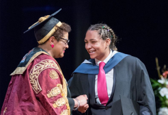 Graduance receiving her graduation certificate from University Chancellor Jackie Kay