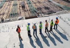 Seven civil engineers survey a building site