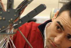 Student in robotics lab operating a robotic hand