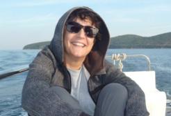 Dr Chrysoula Gubili smiling sitting on a boat in the ocean