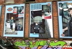 Brick wall lined with poster advertisements for Dickies clothing