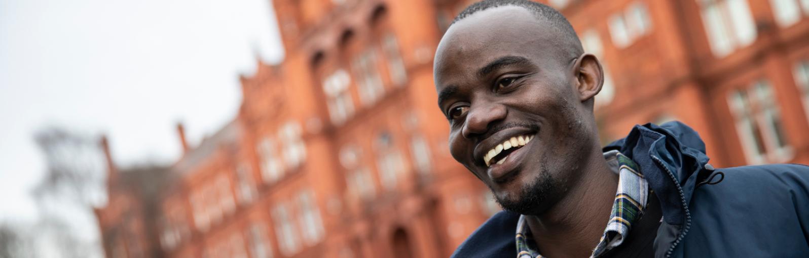 An international student smiling outside Peel Building