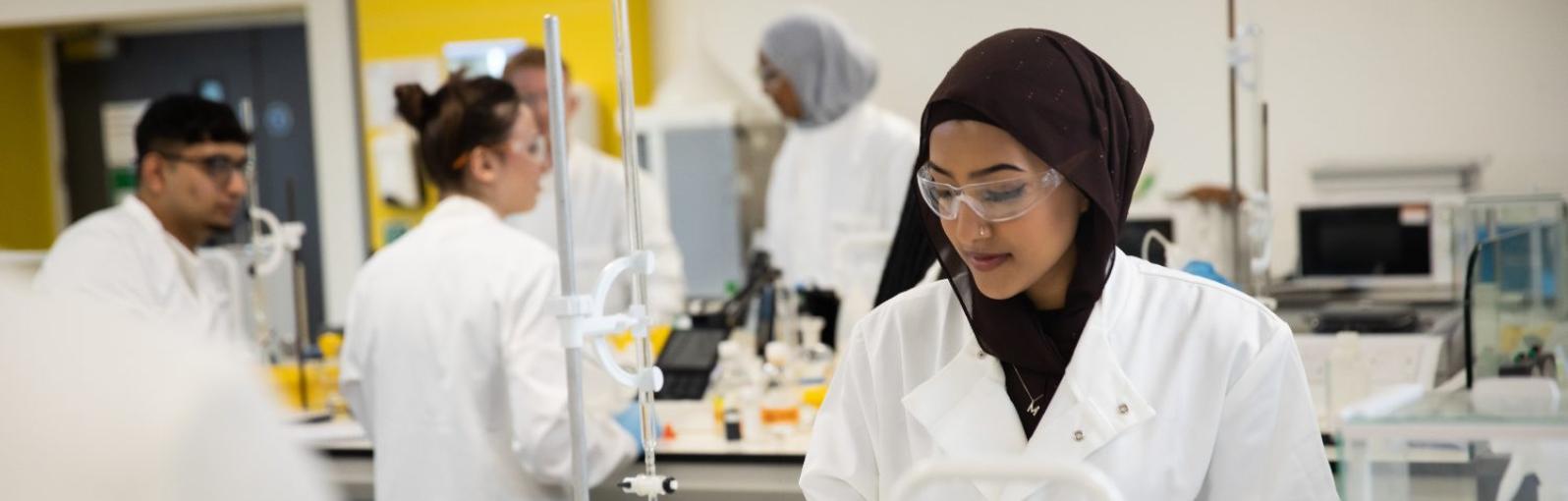 Student looking down at an experiment in a laboratory