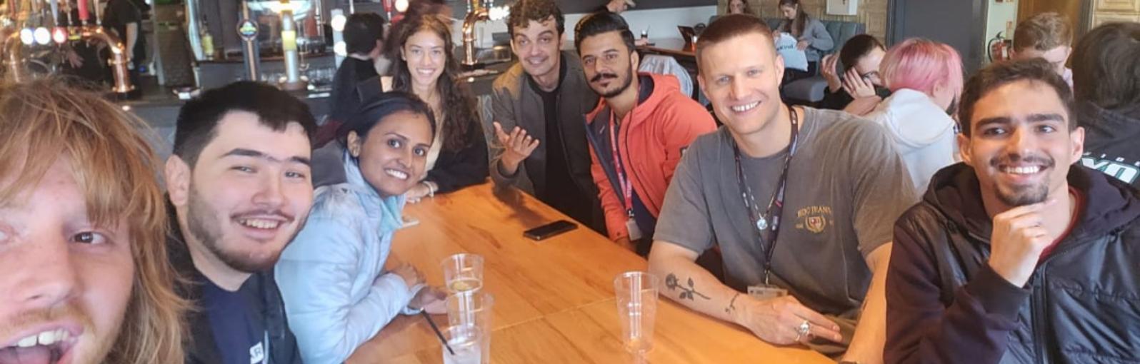 A group of students taking a selfie around a dinner table