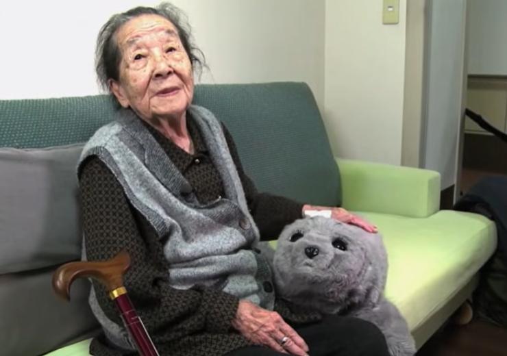Elderly person with an AI robot teddy