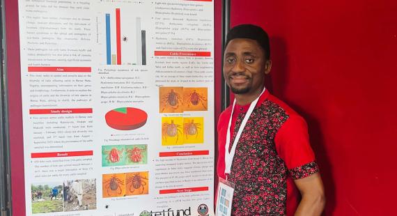 Raymond Ada standing next to a poster at the Montpellier conference