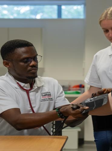Male Clinical Exercise Physiology student conducting manual blood pressure checks on patient