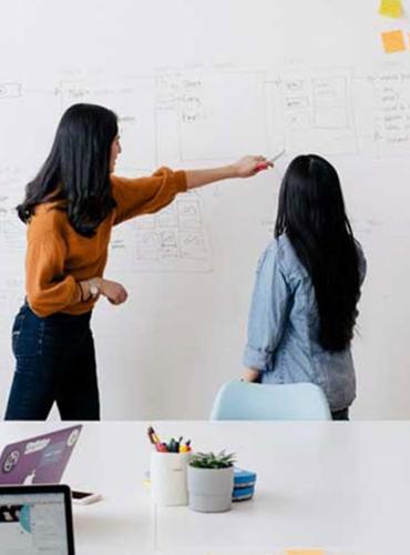 Two people planning using a white board